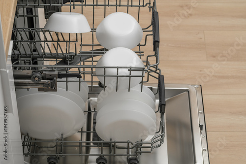 Dishes in the dishwasher, full dishwasher open in the kitchen