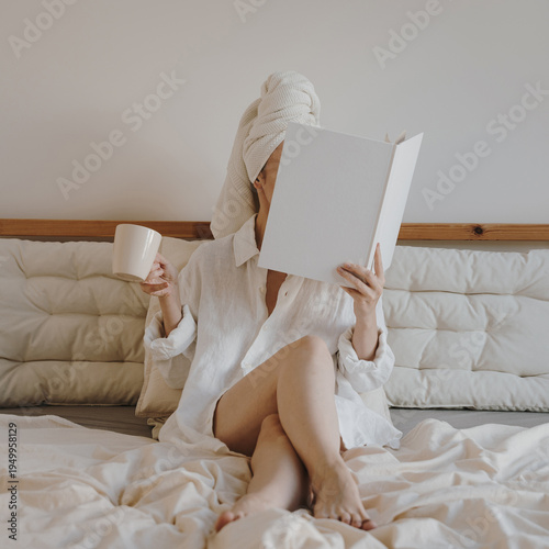 Woman Reading Book and Drinking Coffee in Bed