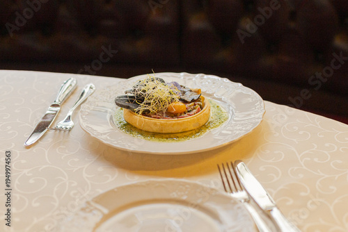 Traditional steak tartare made with raw beef and egg yolk, beautifully plated in a restaurant, highlighting refined presentation and classic European cuisine.