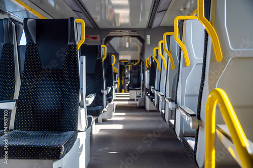 Seats are empty on a modern train during daytime travel in a city