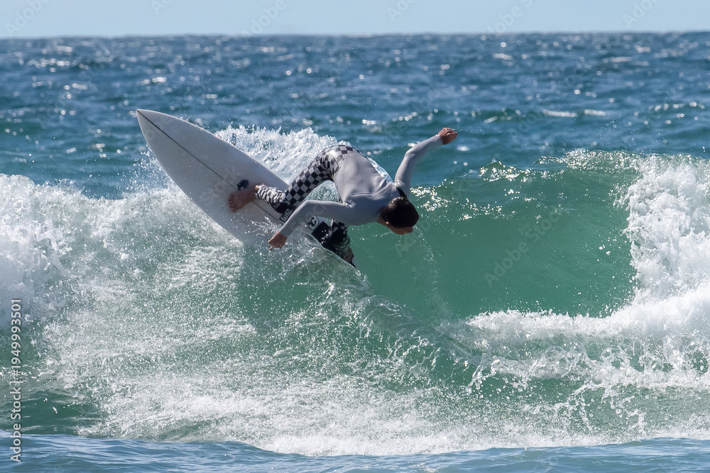 Obraz premium A dynamic action shot of a surfer skillfully riding an ocean wave,