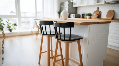 Modern kitchen island creating a central gathering space with stylish black bar stools, showing a contemporary home interior