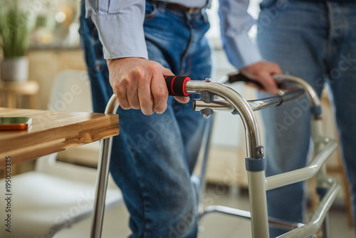 Senior man using walker experiencing mobility challenges at home