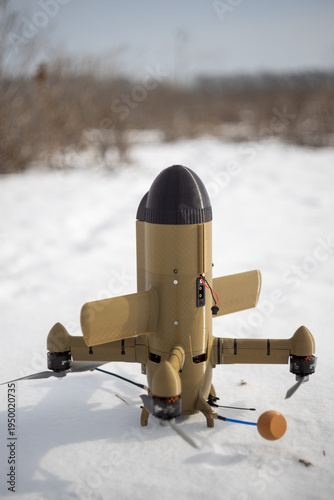FPV interceptor drone with VTOL setup standing on snow in an outdoor field, ready for testing.