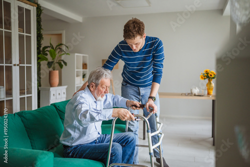 Obraz na płótnie Caregiver assisting senior man with walker at home
