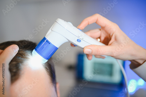 Vászonkép A trichologist examines the hair of a man who begins alopecia