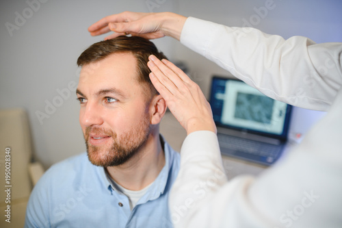 Tableau sur toile A trichologist examines the hair of a man who begins alopecia