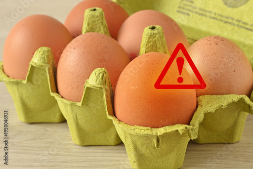 Warning sign on eggs in carton box - Concept of salmonella infection risk, bacterial contamination and health problems