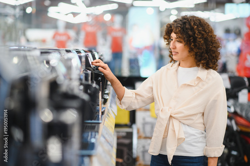 Принти на полотні Woman choosing coffee machine in electronics store
