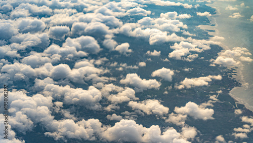 Valokuva Aerial View of Fluffy White Cumulus Clouds Scattered Over a Lush Coastal Landsca