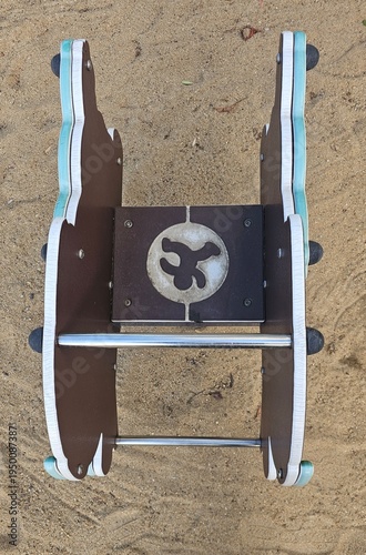 Spring rider playground equipment isolated on sand background