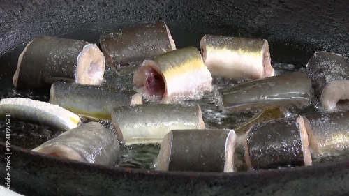 Close up of Eel fish being fried in a pan. Frying eel pieces in a plate