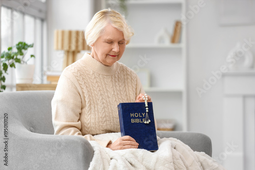 Senior woman praying with b...
