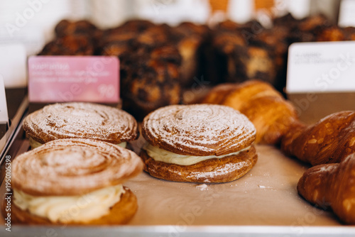 Close up of Paris-Brest pastry on bakery display shelf.