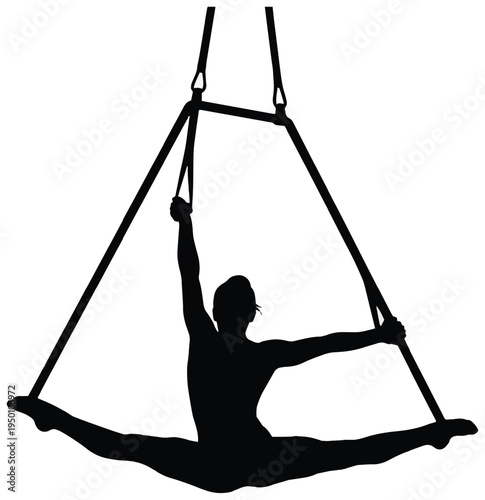 Silhouette of an aerial acrobat performing a full split on a suspended trapeze frame in a studio.