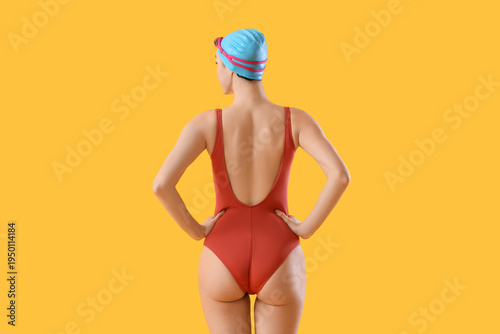 Female swimmer on yellow ba...