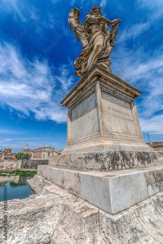 Fototapeta premium ROME, ITALY - JUNE 1, 2017: Statue of Angel from Angel's Bridge by sculptor Ercole Ferrata, in front of castle San Angelo. Vatican Basilica in background.