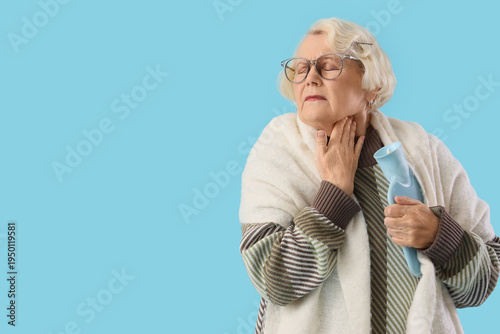 Photography Sick elderly woman with hot water bottle on blue background