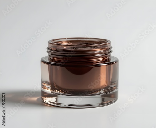 Empty brown glass cosmetic jar with lid threads on a white background