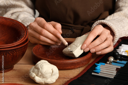 Female sculptor carving cla...