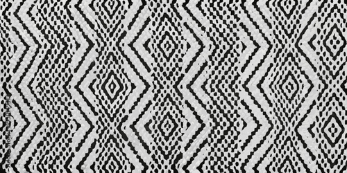 Close up of a black and white woven textile with a diamond pattern