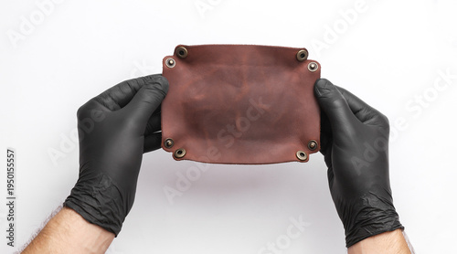 Slika na platnu Tanner holds a leather organizer on a white background