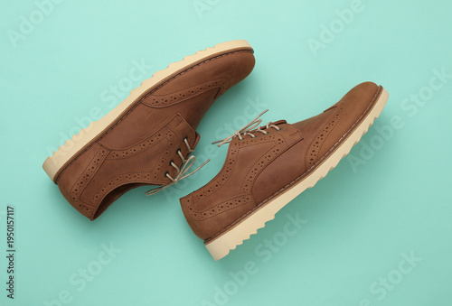 Obraz na plátně Brown leather brogue boots on a blue background