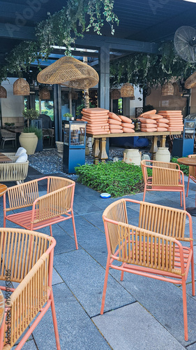 Cozy Outdoor Restaurant Patio With Pink Chairs and Hanging Wicker Lamps