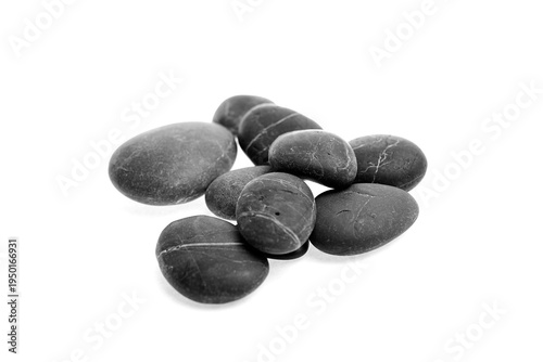 Photography Black pebble stones arranged in a natural formation on a white background, showc
