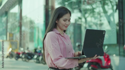 Smiling young woman talking on a smartphone outdoors in an urban area, expressing friendly communication, mobile connectivity, and modern digital lifestyle.