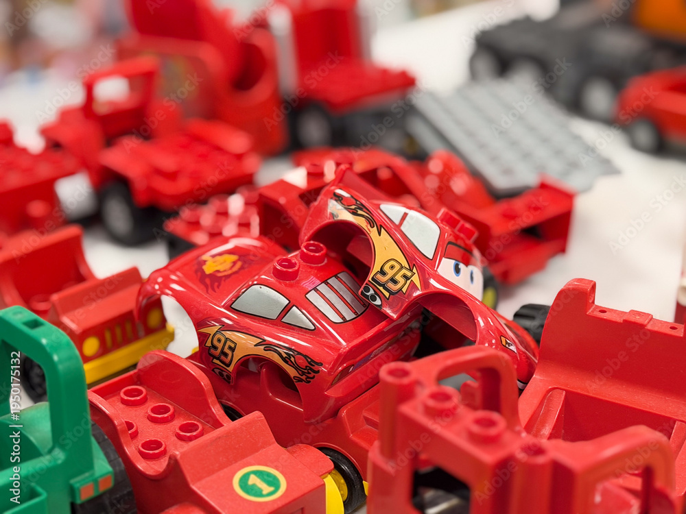 Fototapeta premium Red toy race car among red building blocks