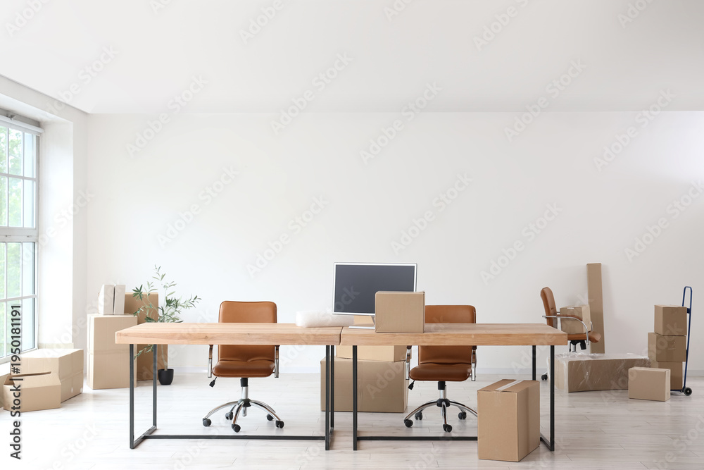 Fototapeta premium Workplace with chairs and cardboard boxes in office on moving day