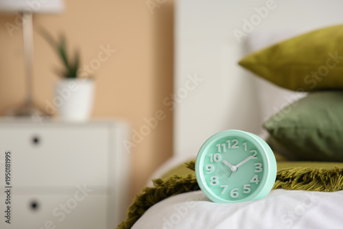 Alarm clock on bed, closeup