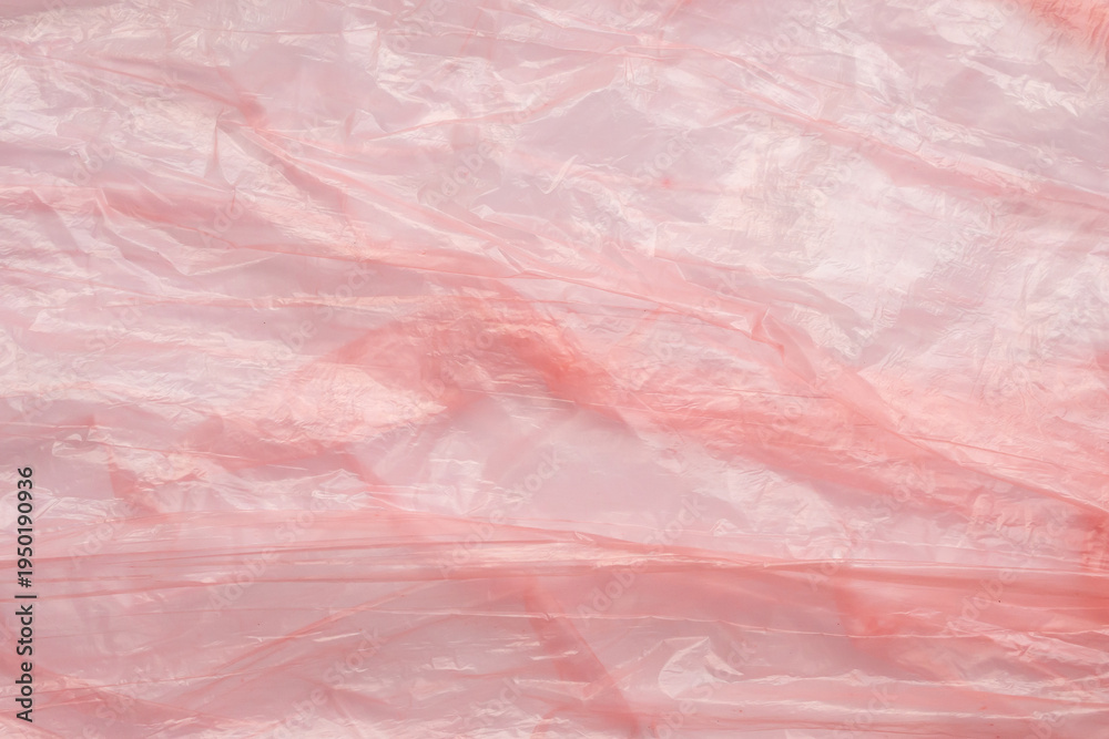 Fototapeta premium Crumpled red plastic texture, wrinkled polyethylene bag surface background