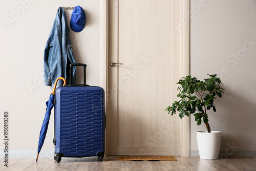 Packed suitcase, umbrella a...