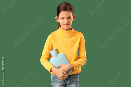 Canvas Print Teenage girl with appendicitis and hot water bottle on green background