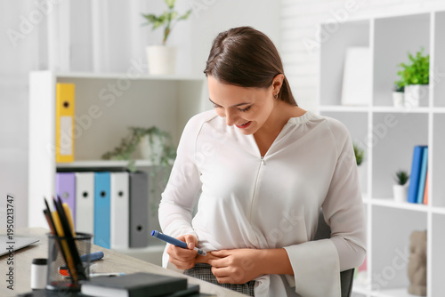 Diabetic woman giving herself insulin injection in office