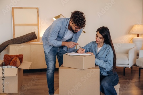 Wallpaper Mural Focused, writing on the paper. Couple reviewing documents and planning their new home after moving Torontodigital.ca