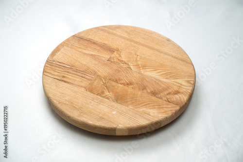 Round wooden cutting board on a light background, kitchen accessory