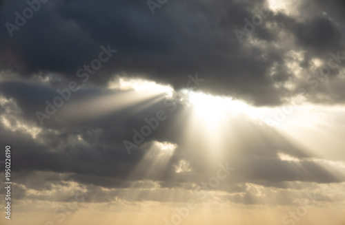 Fotografia Dramatic sun rays breaking through dark storm clouds over Caribbean sea near Coz