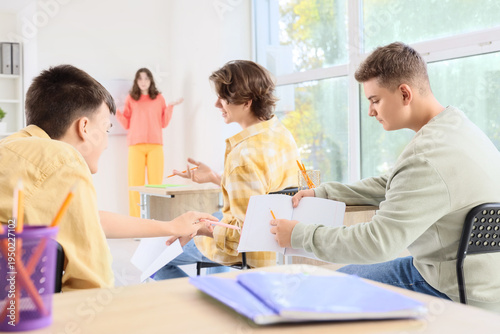 Quadro su tela Teenage students ignoring their classmate during lesson at school