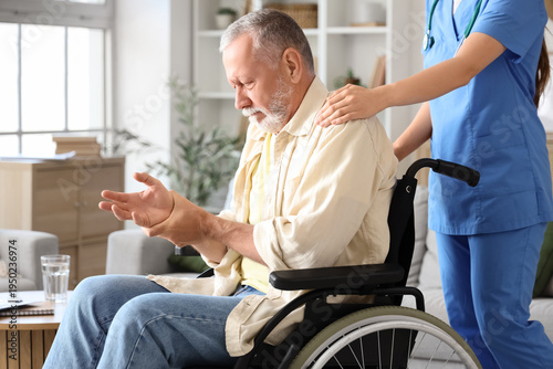 Εκτύπωση καμβά Senior man suffering from Parkinson syndrome in wheelchair with nurse at home