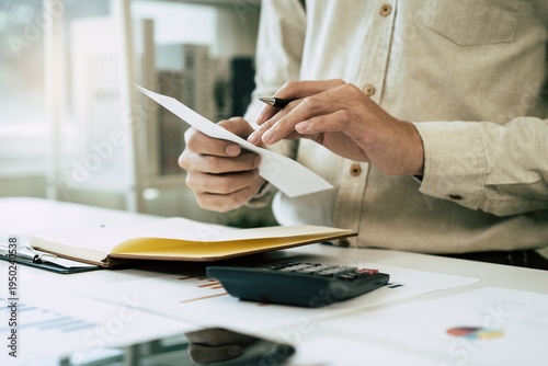 Foto Deduction planning, debt asian accountant hand using calculator to calculating money balance from bill and income, cost budget expenses for pay money form personal individual on table at home
