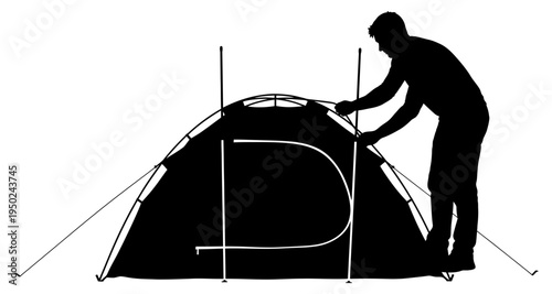 A man is setting up a dark colored tent outdoors in silhouette