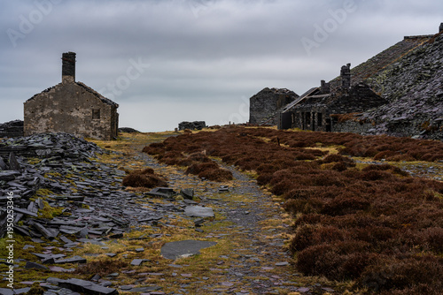 Derelict stone workshops and mining structures along a slate path at Dinorwic slate quarry in Gwynedd, Snowdonia