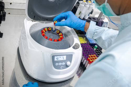 Canvastavla A lab technician wearing blue gloves carefully places a blood sample test tube i