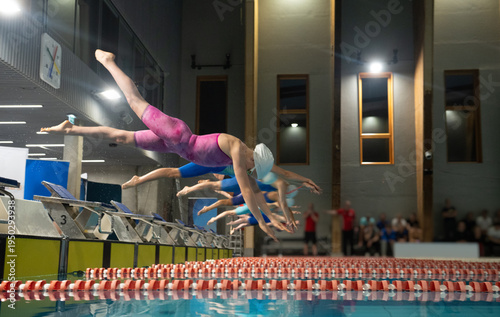 Female swimmers start from the starting table in the swimming pool