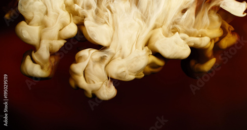 Abstract macro of milk mixing with coffee creating flowing creamy patterns and fluid shapes. Swirling liquid forms soft textures and organic motion, forming a dramatic beverage background.