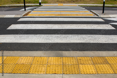 low angle view of a pedestrian crossing withtactile paving tiles. raised truncated domes with a detectable warning surface for visually impaired pedestrians. transportation background