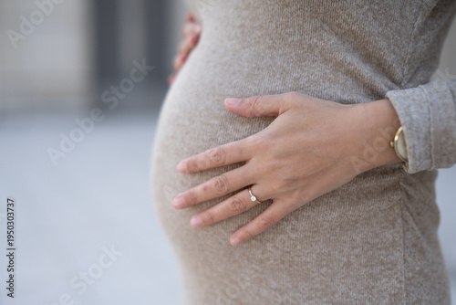 Gros plan sur le ventre d'une femme enceinte portant une bague
